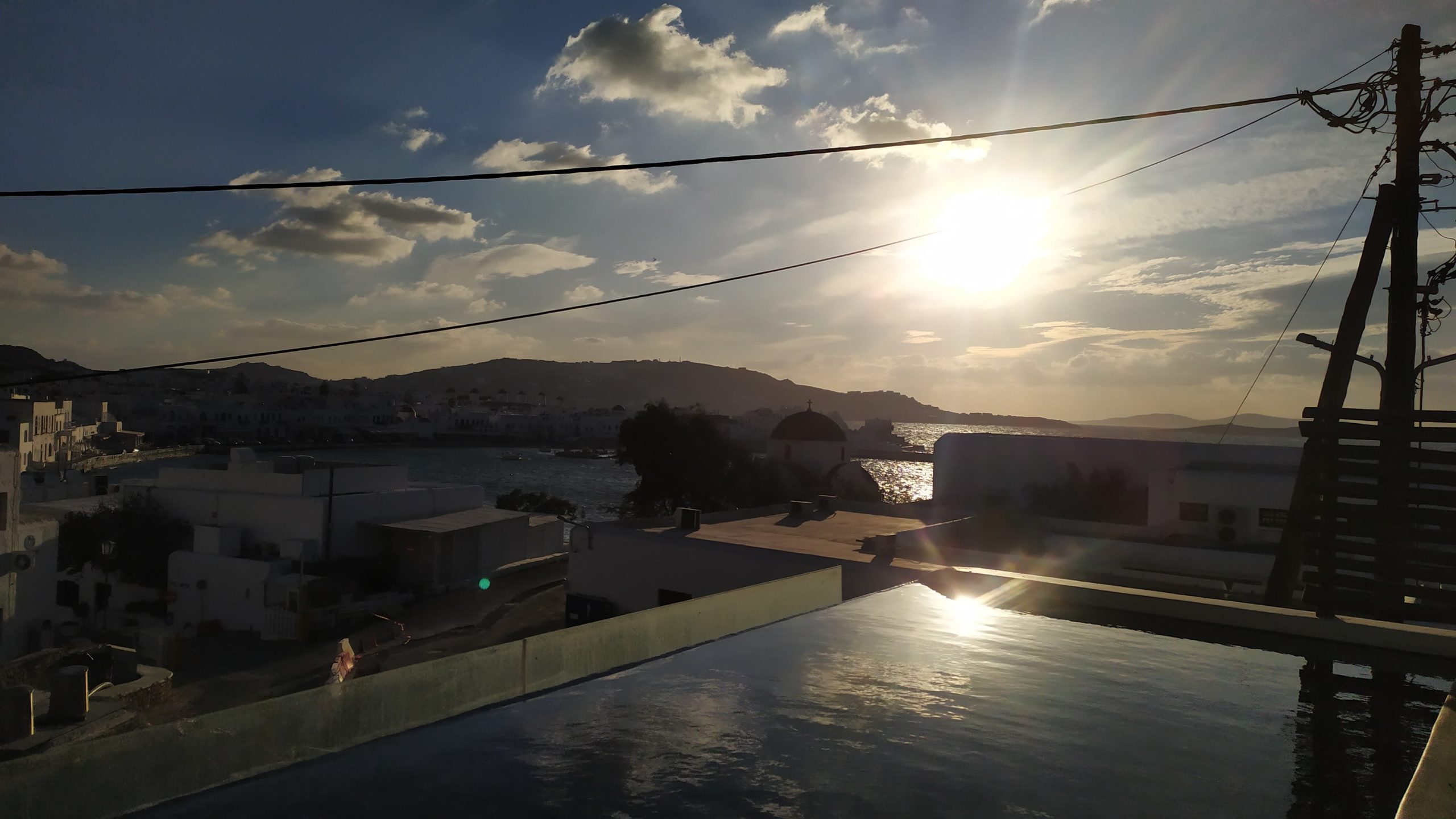 Une piscine à débordement éclairée par le coucher du soleil