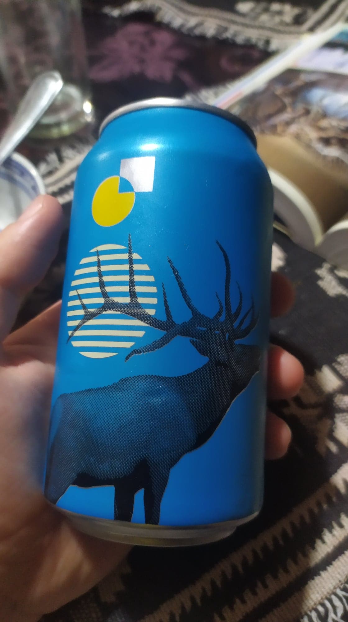 une canette de bière bleue avec un logo de cerf qui brame pendant la pleine lune